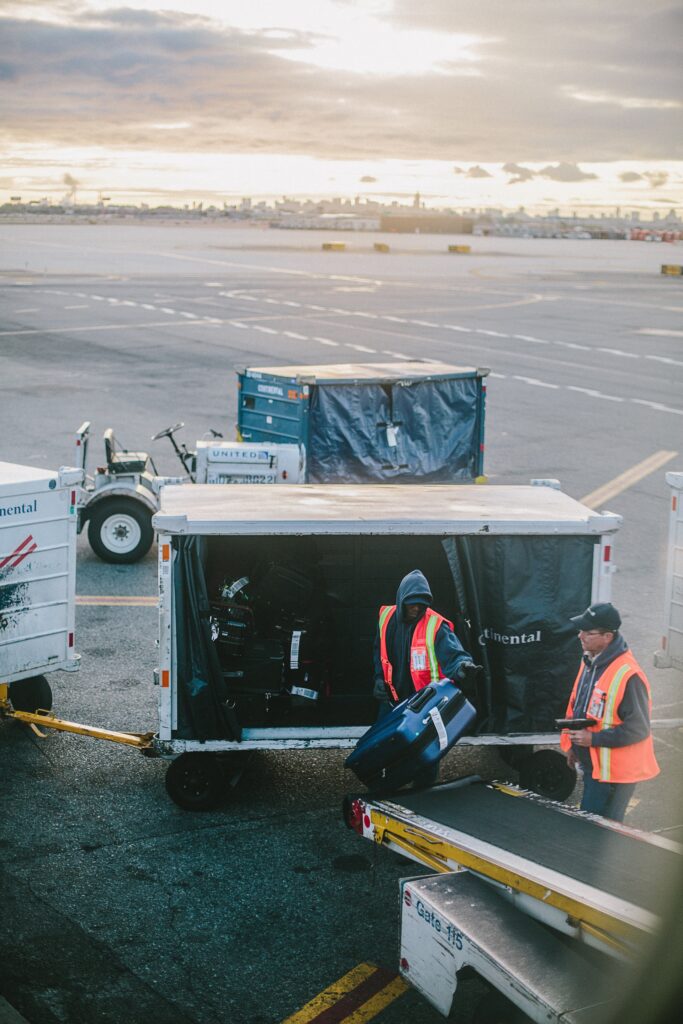 Airport crew loading in bags for someone whos is moving to Colombia